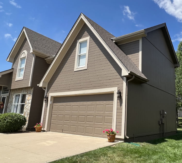 Finished exterior house painting project in Kansas City MO, showing brown siding, trim, and garage door