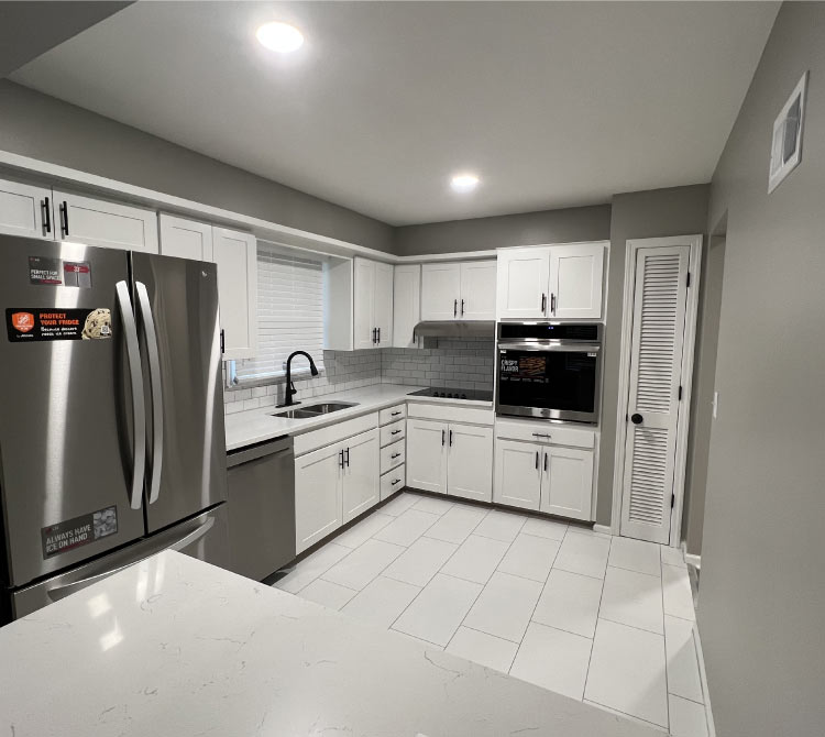 Professional cabinet painting and kitchen renovation in a modern Kansas City home, featuring white shaker cabinets and subway tile backsplash