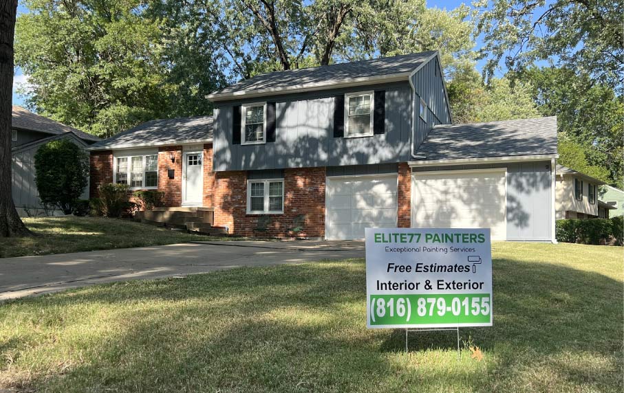 How Much Does It Cost to Paint a House? Renovated split-level home featuring new blue-grey exterior paint and the Elite 77 Painters yard sign in Kansas City