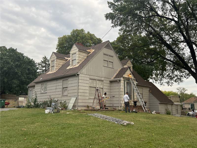 Professional painting crew performing essential prep work and scraping on a vintage home exterior to ensure a long-lasting finish