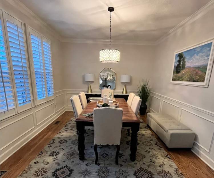 Freshly painted interior dining room with detailed white wainscoting and light grey walls showing high-quality trim work