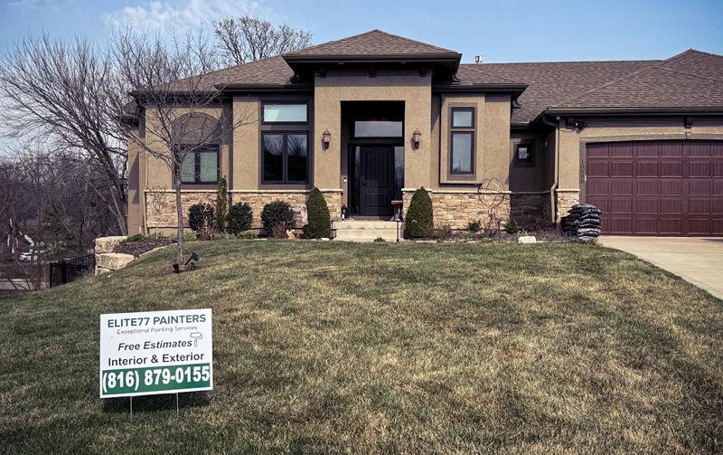 Freshly painted tan stucco home with Elite77 Painters yard sign - free estimates interior and exterior painting