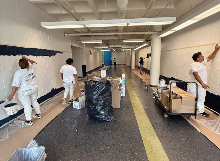 Elite77 painting crew painting interior block walls of a commercial facility in Kansas City, with floors protected